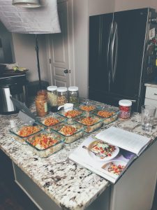 kitchen counter with meal prep monday dishes of kung poa chickpeas and cookbook