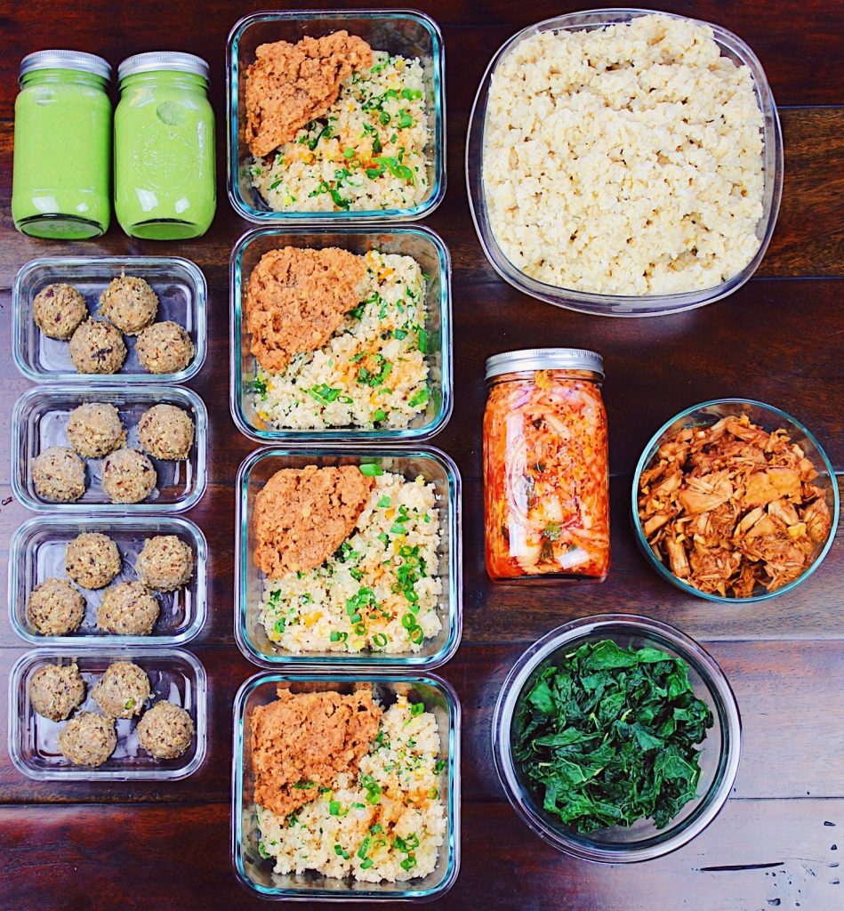 meal prep monday with protein packed energy bites, green smoothies, spiced lentils with cauliflower rice, and korean bbq jack fruit bowls on table